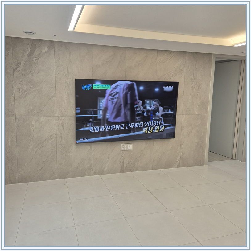 우드 톤 가구와 이어지는 벽면 화면, TV 설치 참고 사진