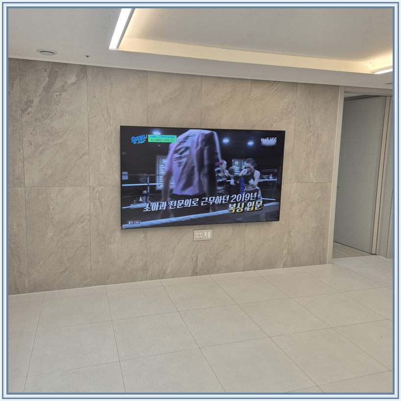 우드 톤 가구와 이어지는 벽면 화면, TV 설치 참고 사진
