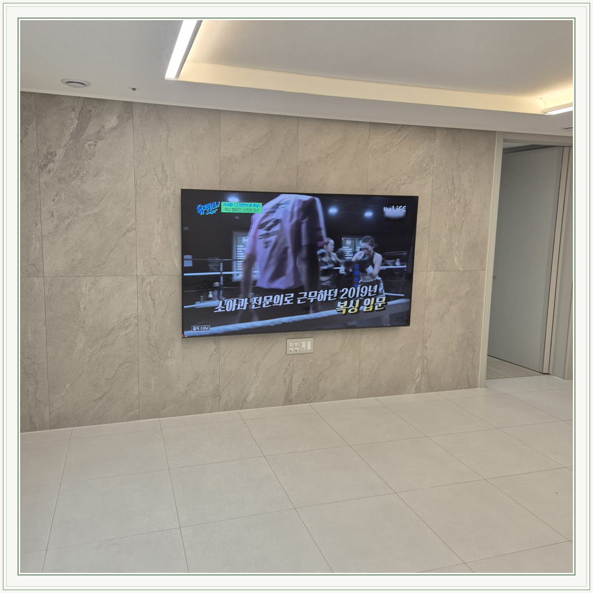 우드 톤 가구와 이어지는 벽면 화면, TV 설치 참고 사진
