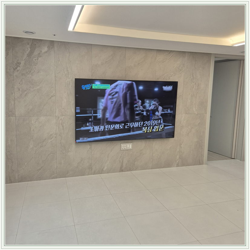 우드 톤 가구와 이어지는 벽면 화면, TV 설치 참고 사진
